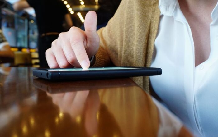 woman scrolling through her phone in a coffee shop